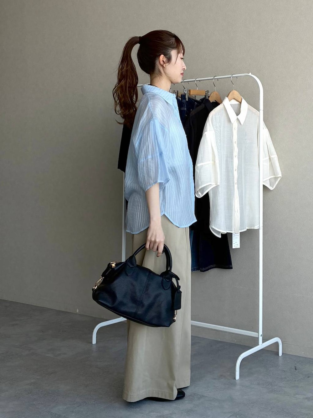ブラック系のボストンバッグ、ブラック系のローファー、ブルー系のシャツ/ブラウスを着用したレディースの春コーディネートの4枚目の写真