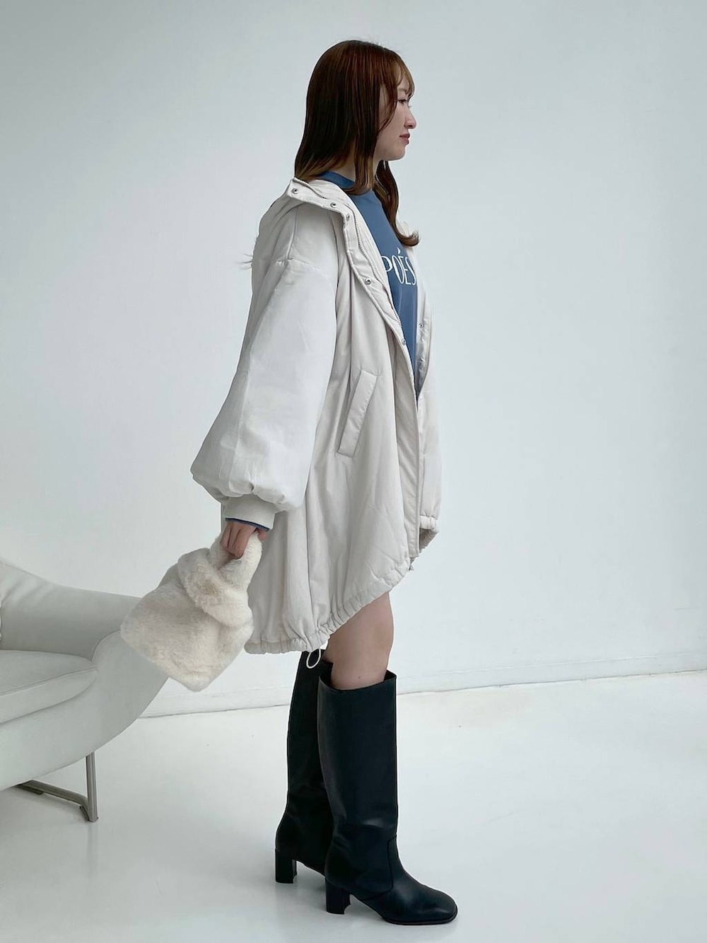 ホワイト系のブルゾン、ブラック系のブーツ、ホワイト系のスカートを着用したレディースの秋コーディネートの4枚目の写真