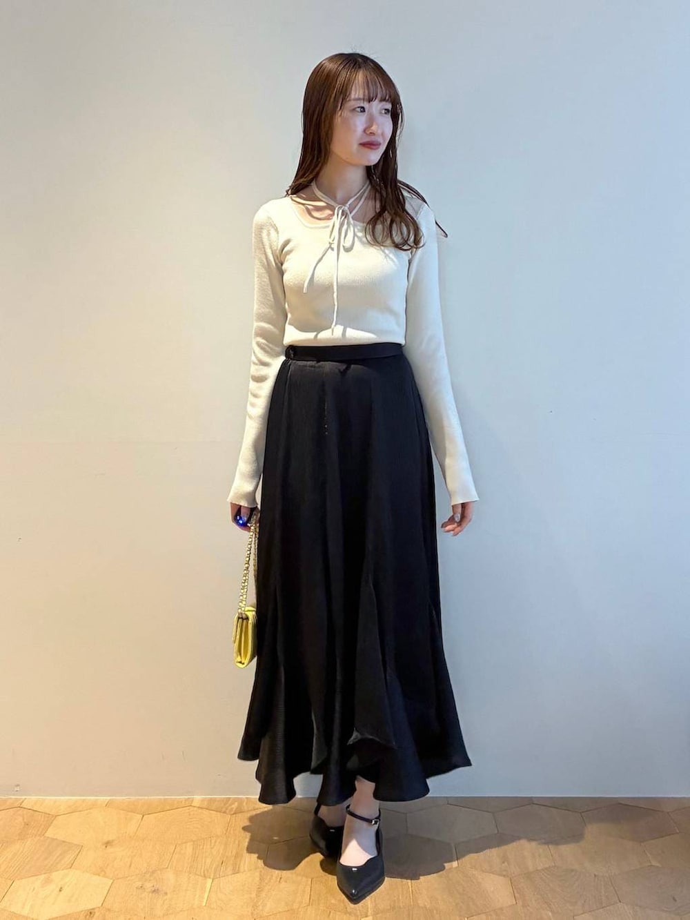 ブラック系のパンプス、ホワイト系のニット/セーター、ホワイト系のノーカラージャケットを着用したレディースの春コーディネートの6枚目の写真