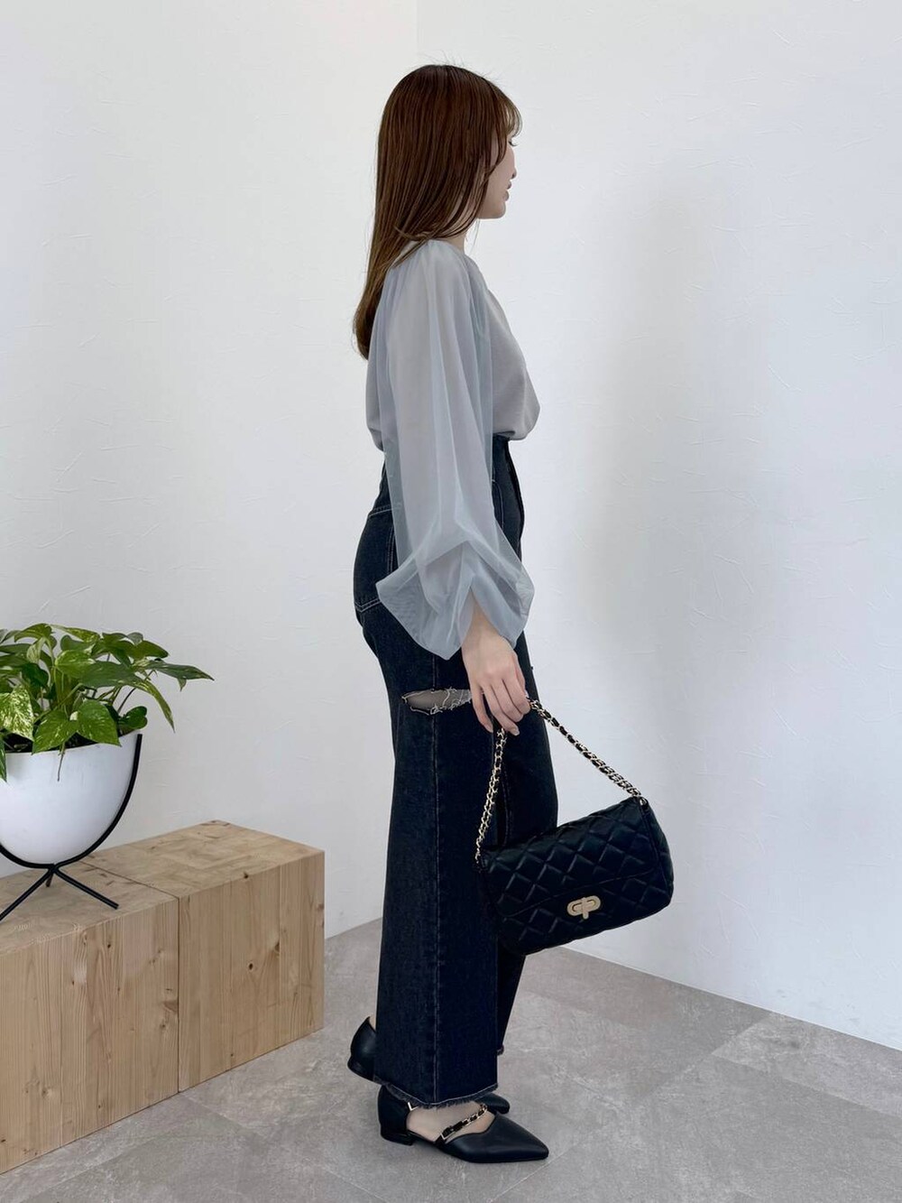 グレー系のTシャツ/カットソー、ブラック系のショルダーバッグ、ブラック系のデニムパンツを着用したレディースの冬コーディネートの2枚目の写真