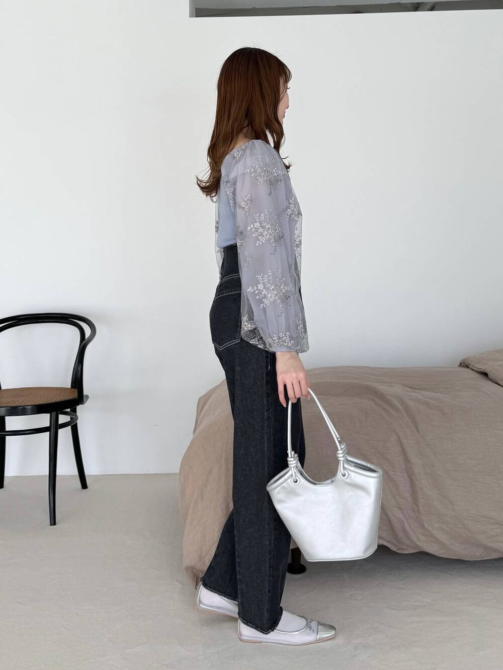 シルバー系のバレエシューズ、ブラック系のデニムパンツ、ブルー系のニット/セーターを着用したレディースの春コーディネートの2枚目の写真