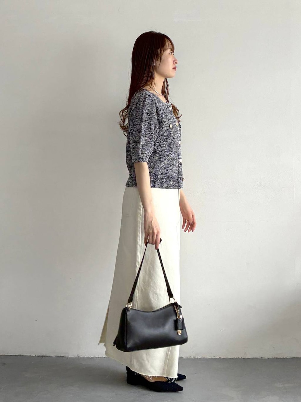 ブルー系のカーディガン/ボレロ、ブルー系のパンプス、ブラック系のショルダーバッグを着用したレディースの春コーディネートの4枚目の写真