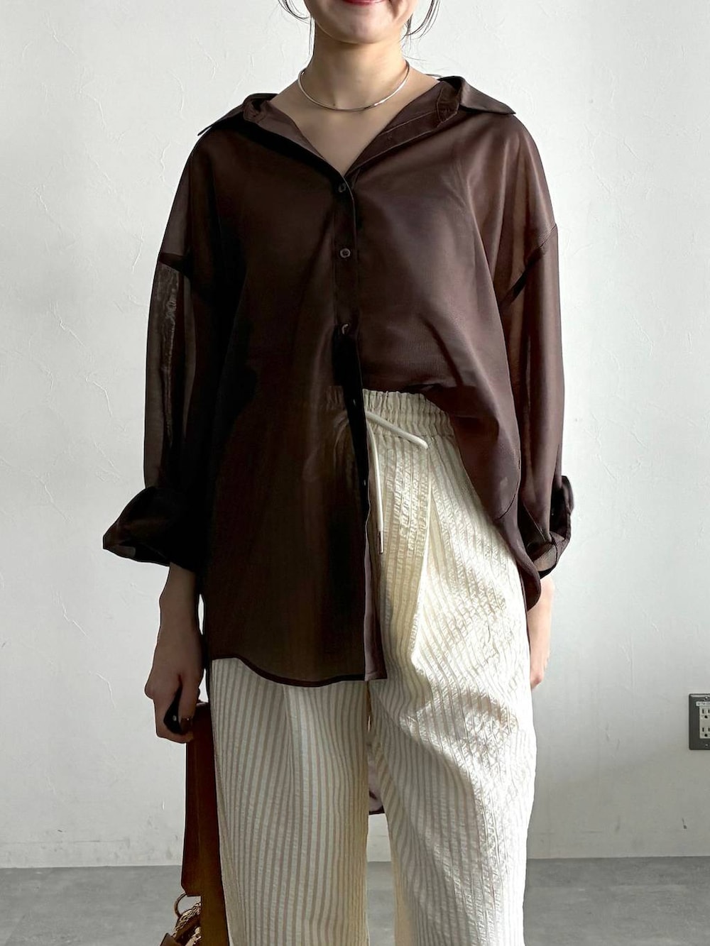 ブラウン系のシャツ/ブラウス、ホワイト系のサンダル、ベージュ系のその他パンツを着用したレディースの春コーディネートの6枚目の写真