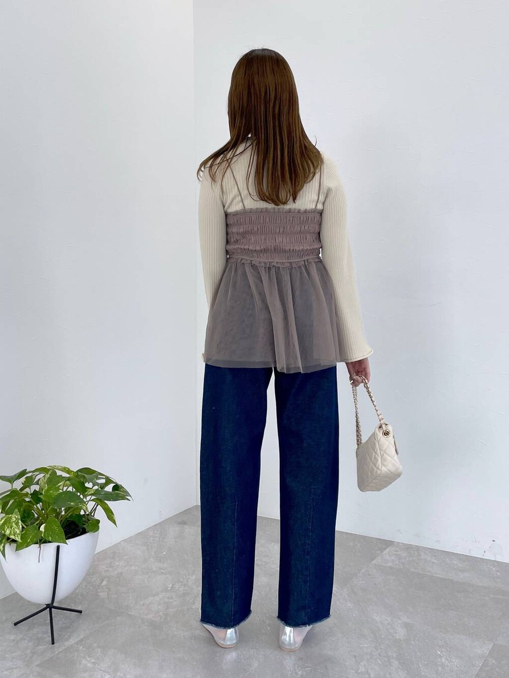 シルバー系のバレエシューズ、ホワイト系のショルダーバッグ、ブラウン系のニット/セーターを着用したレディースの春コーディネートの3枚目の写真