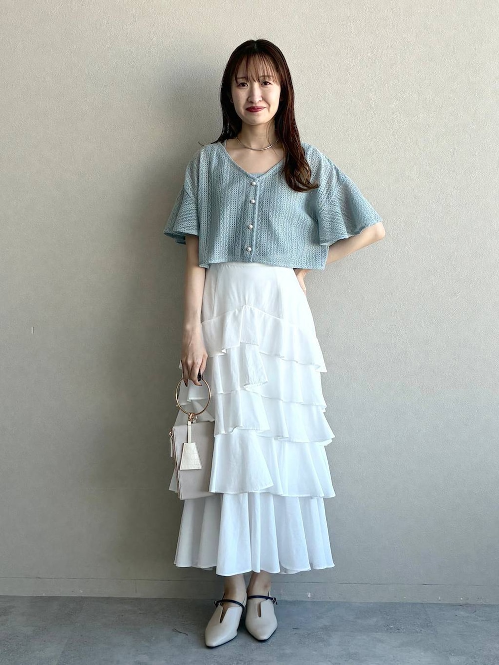 ブルー系のカーディガン/ボレロ、ホワイト系のサンダル、グレー系のショルダーバッグを着用したレディースの春コーディネートの5枚目の写真