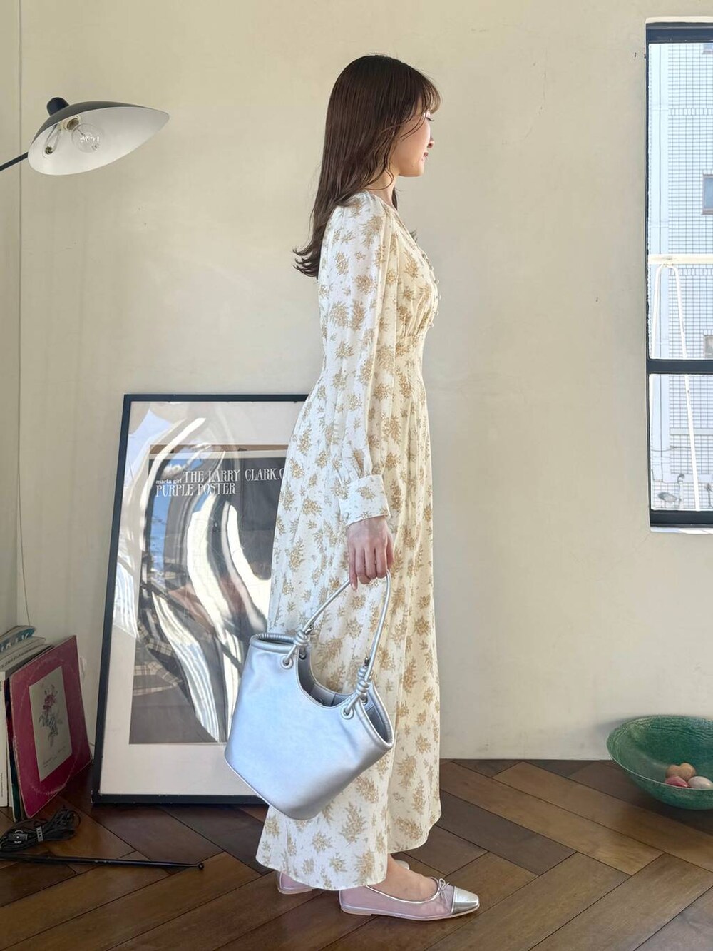 シルバー系のバレエシューズ、イエロー系のワンピース、シルバー系のハンドバッグを着用したレディースの冬コーディネートの2枚目の写真