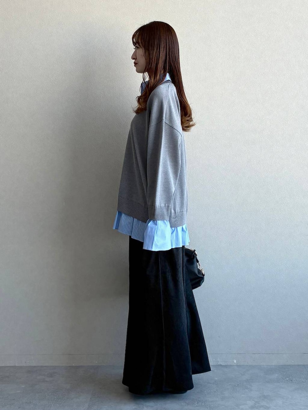 ブラック系のスカート、ブラック系のボストンバッグ、ブラック系のローファーを着用したレディースの冬コーディネートの2枚目の写真