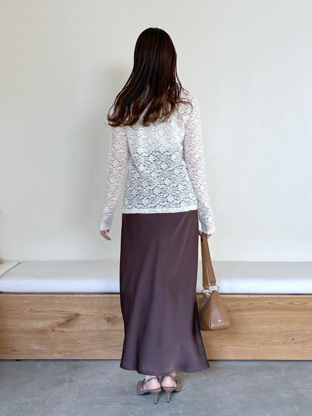 ブラウン系のサンダル、ブラウン系のスカート、ホワイト系のTシャツ/カットソーを着用したレディースの冬コーディネートの3枚目の写真