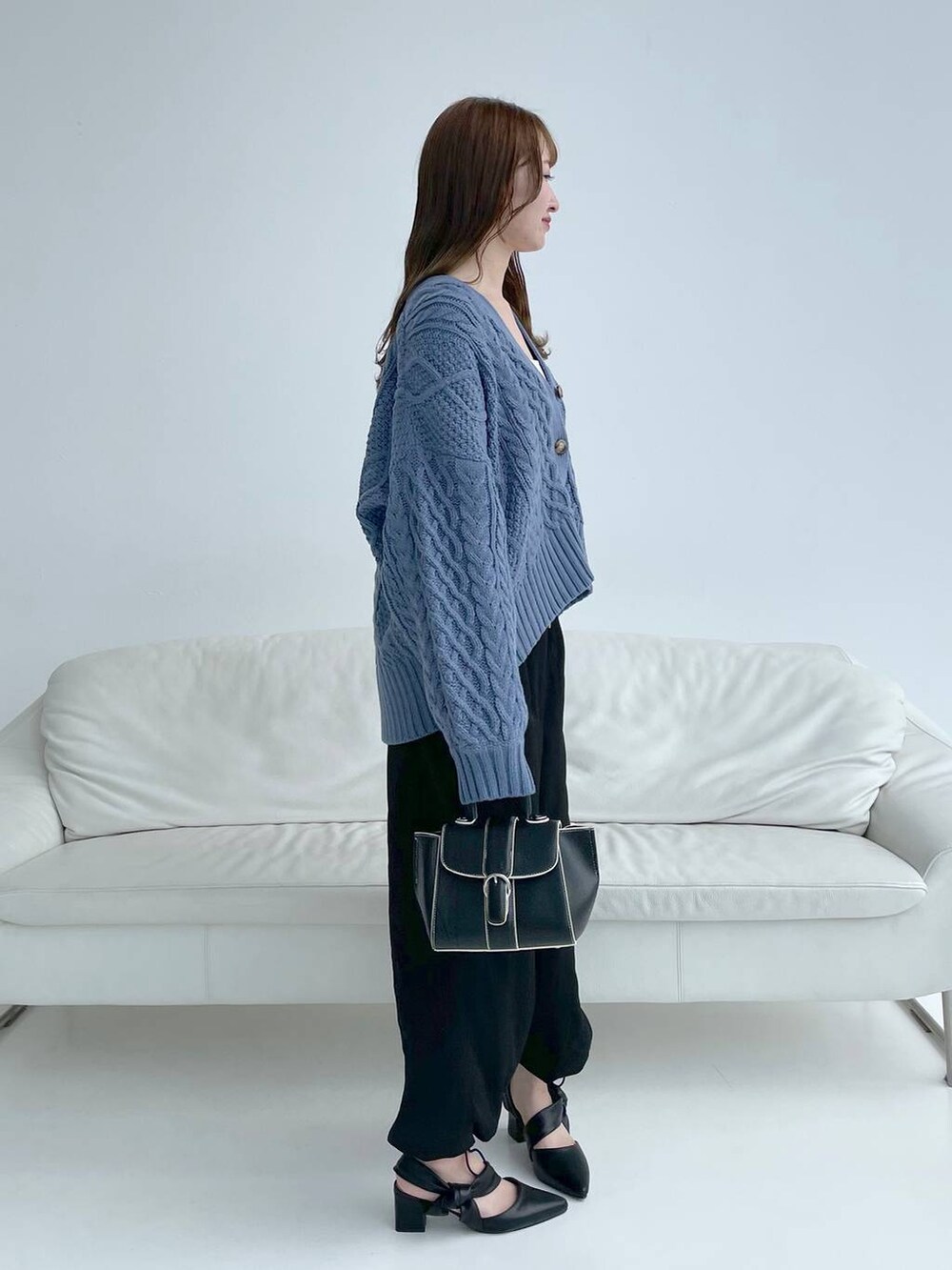 ホワイト系のキャミソール、ブラック系のハンドバッグ、ブラック系のパンプスを着用したレディースの秋コーディネートの4枚目の写真