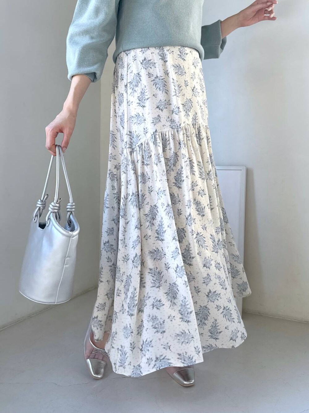 シルバー系のバレエシューズ、ブルー系のスカート、グリーン系のニット/セーターを着用したレディースの冬コーディネートの5枚目の写真