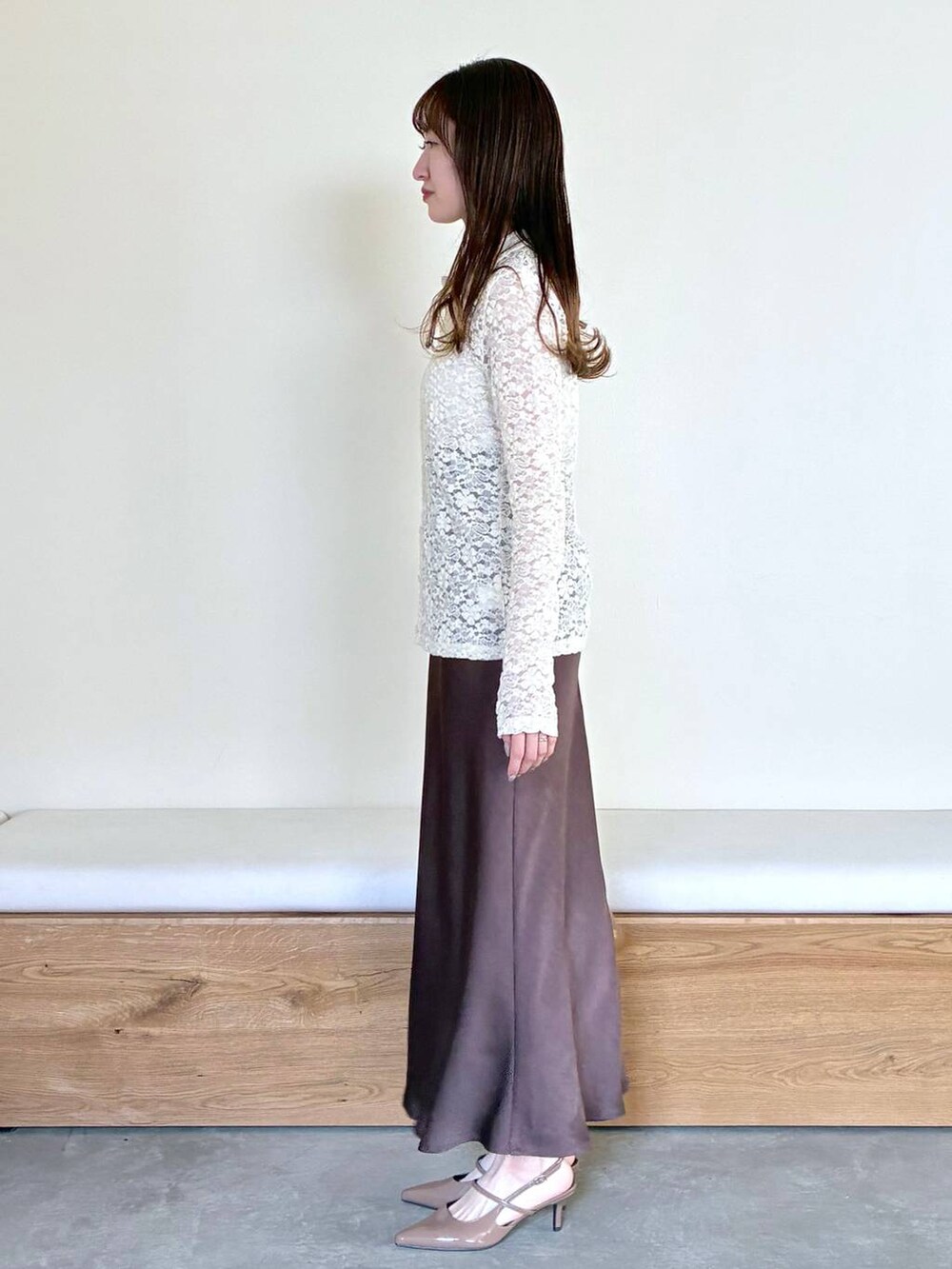 ブラウン系のサンダル、ブラウン系のスカート、ホワイト系のTシャツ/カットソーを着用したレディースの冬コーディネートの2枚目の写真