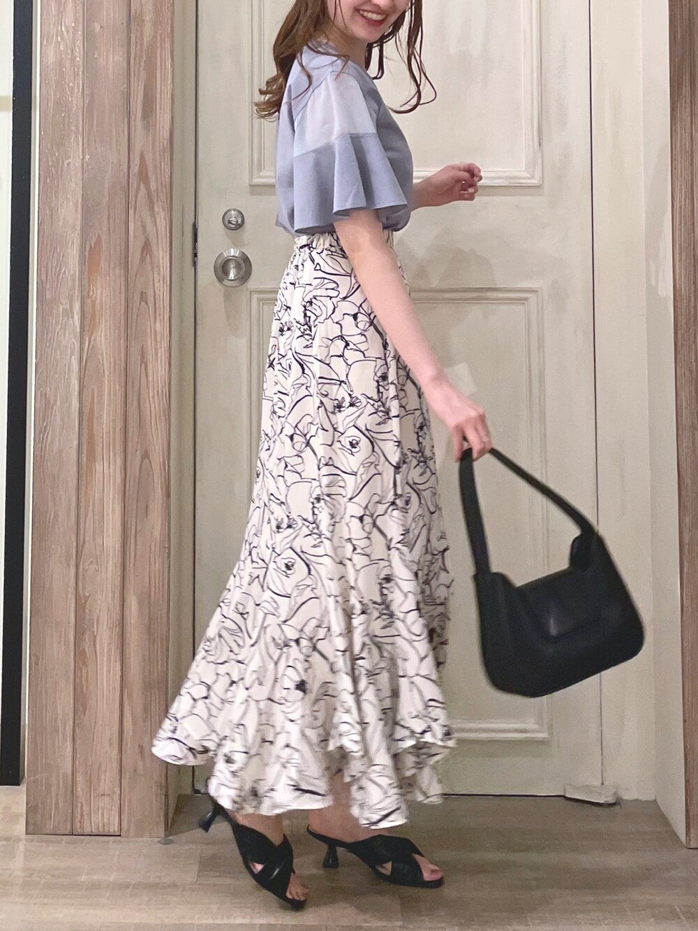 ブルー系のTシャツ/カットソー、ホワイト系のスカート、ブラック系のハンドバッグを着用したレディースの夏コーディネートの4枚目の写真
