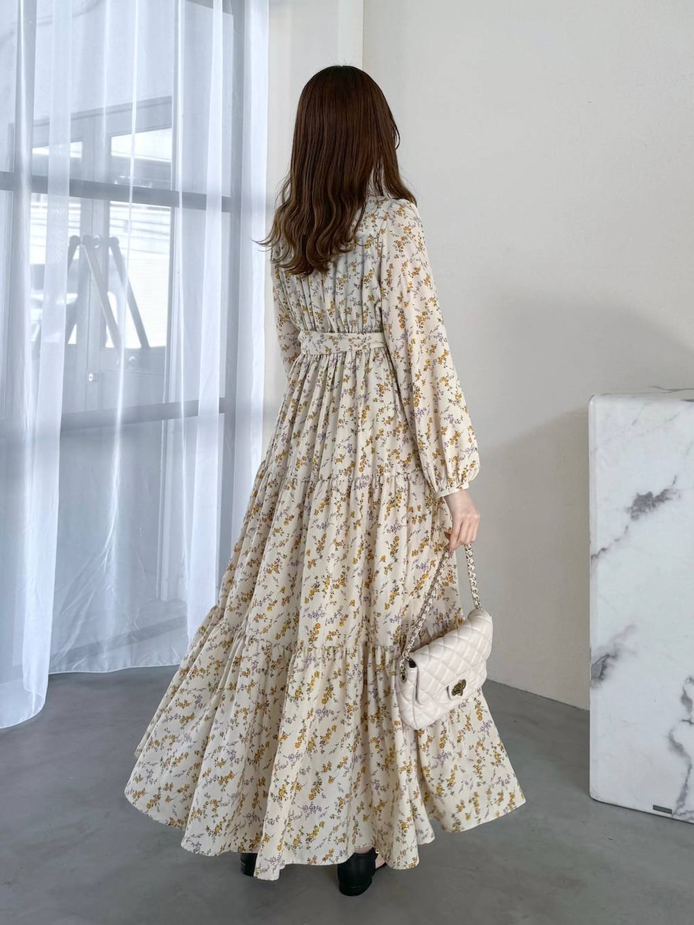 ブラック系のタンクトップ、ホワイト系のショルダーバッグ、ブラック系のパンプスを着用したレディースの冬コーディネートの3枚目の写真