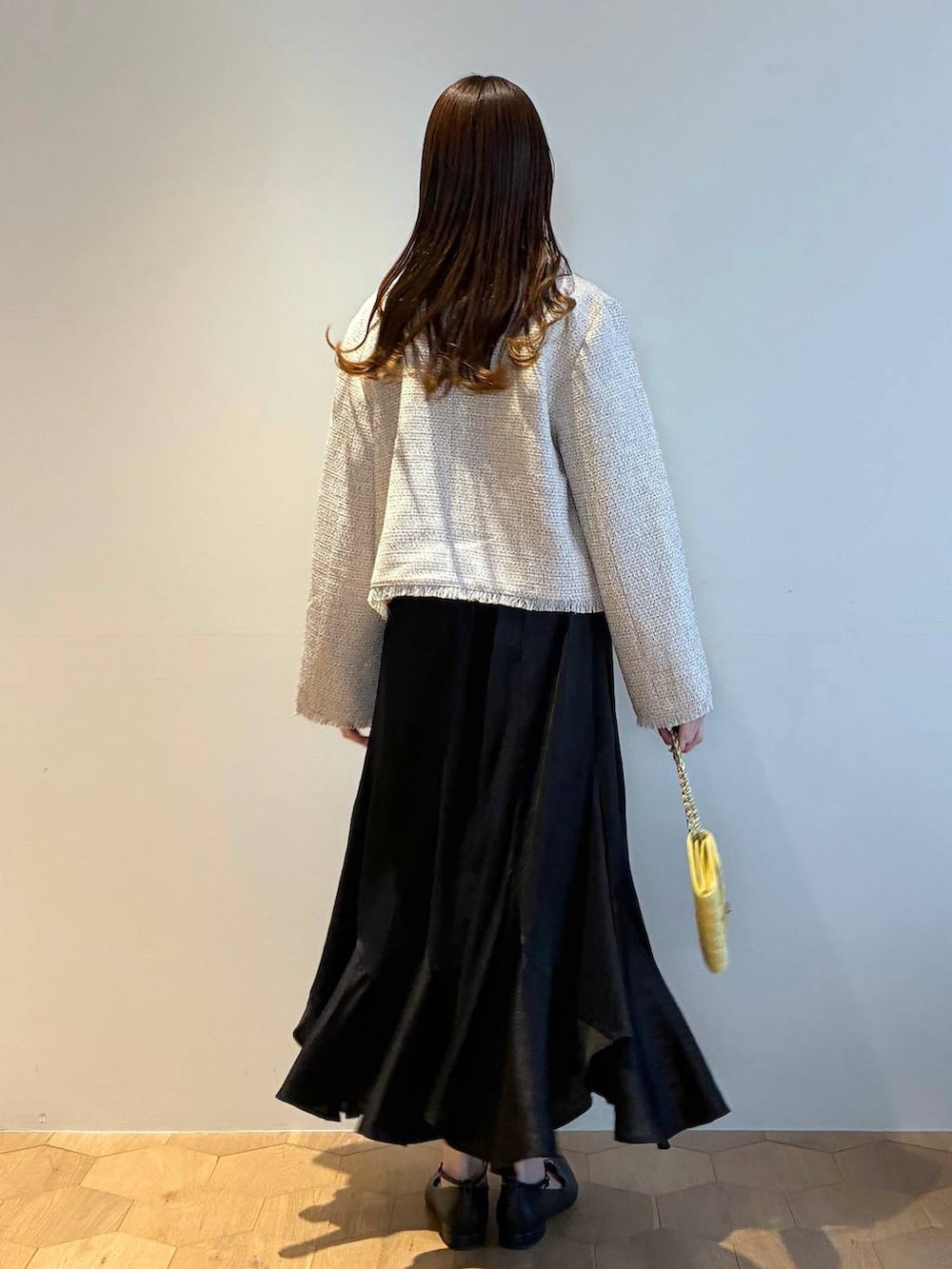 ブラック系のパンプス、ホワイト系のニット/セーター、ホワイト系のノーカラージャケットを着用したレディースの春コーディネートの3枚目の写真