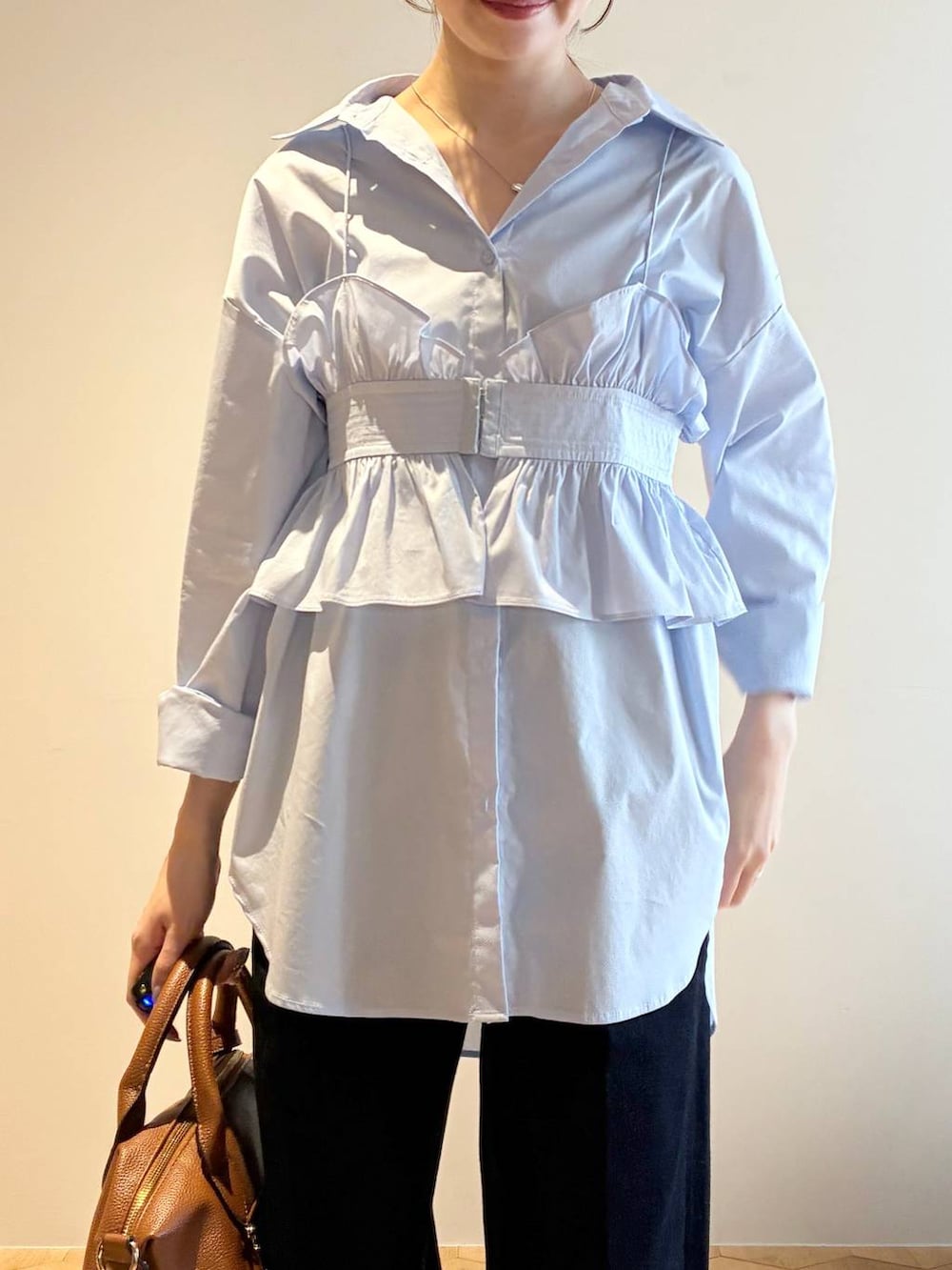 ブラウン系のボストンバッグ、ブラウン系のサンダル、ブルー系のシャツ/ブラウスを着用したレディースの冬コーディネートの6枚目の写真