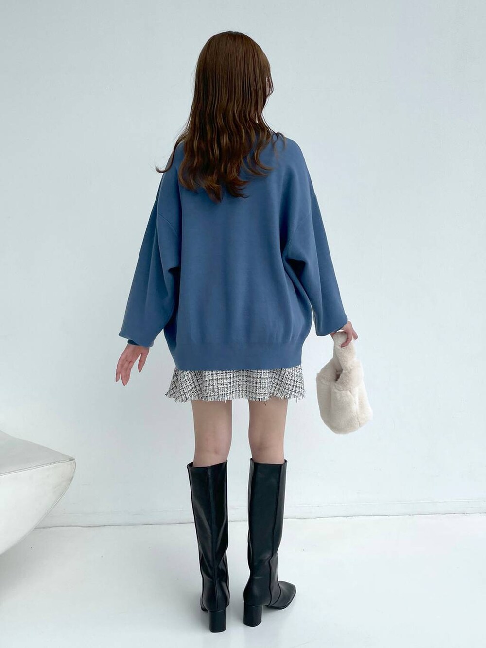 ホワイト系のブルゾン、ブラック系のブーツ、ホワイト系のスカートを着用したレディースの秋コーディネートの7枚目の写真