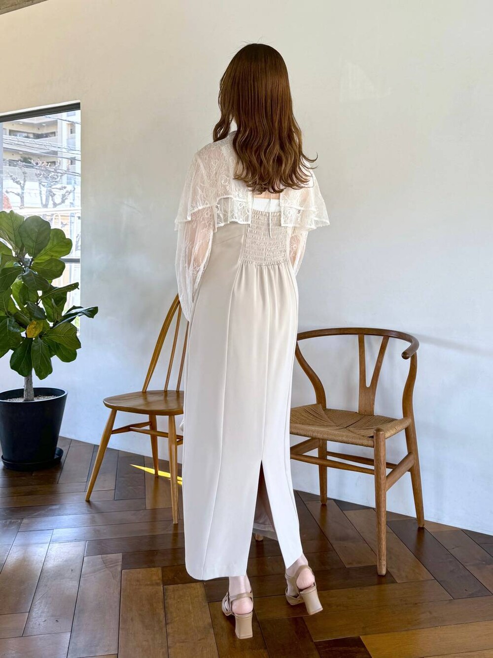 ホワイト系のドレス、ホワイト系のショルダーバッグ、ベージュ系のパンプスを着用したレディースの冬コーディネートの3枚目の写真