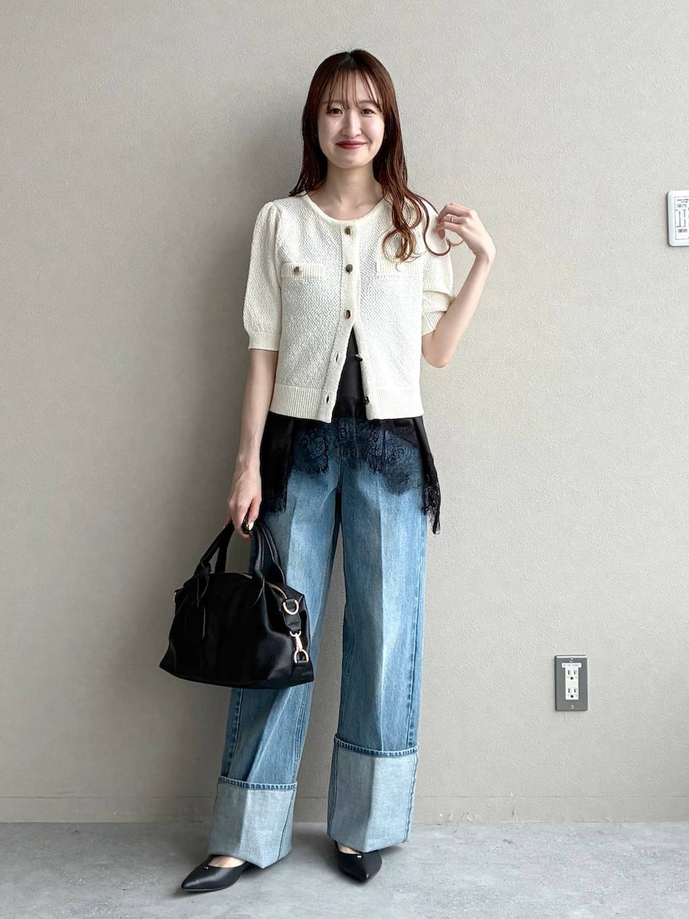 ブラック系のボストンバッグ、ホワイト系のカーディガン/ボレロ、ブラック系のパンプスを着用したレディースの春コーディネートの5枚目の写真
