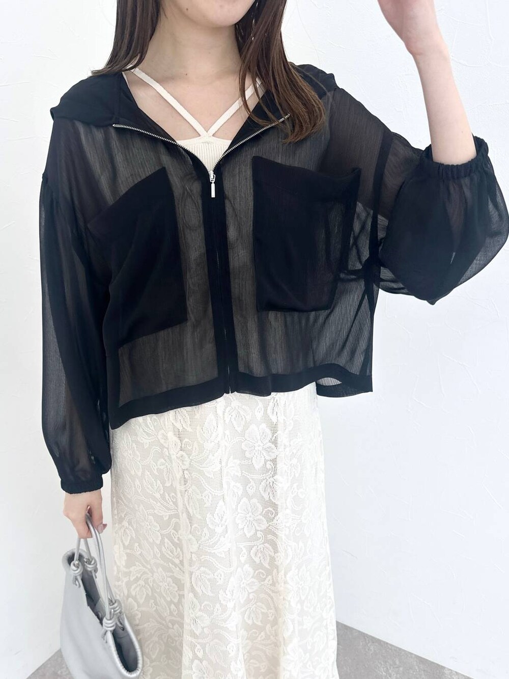 シルバー系のバレエシューズ、ホワイト系のワンピース、ブラック系のパーカーを着用したレディースの春コーディネートの4枚目の写真