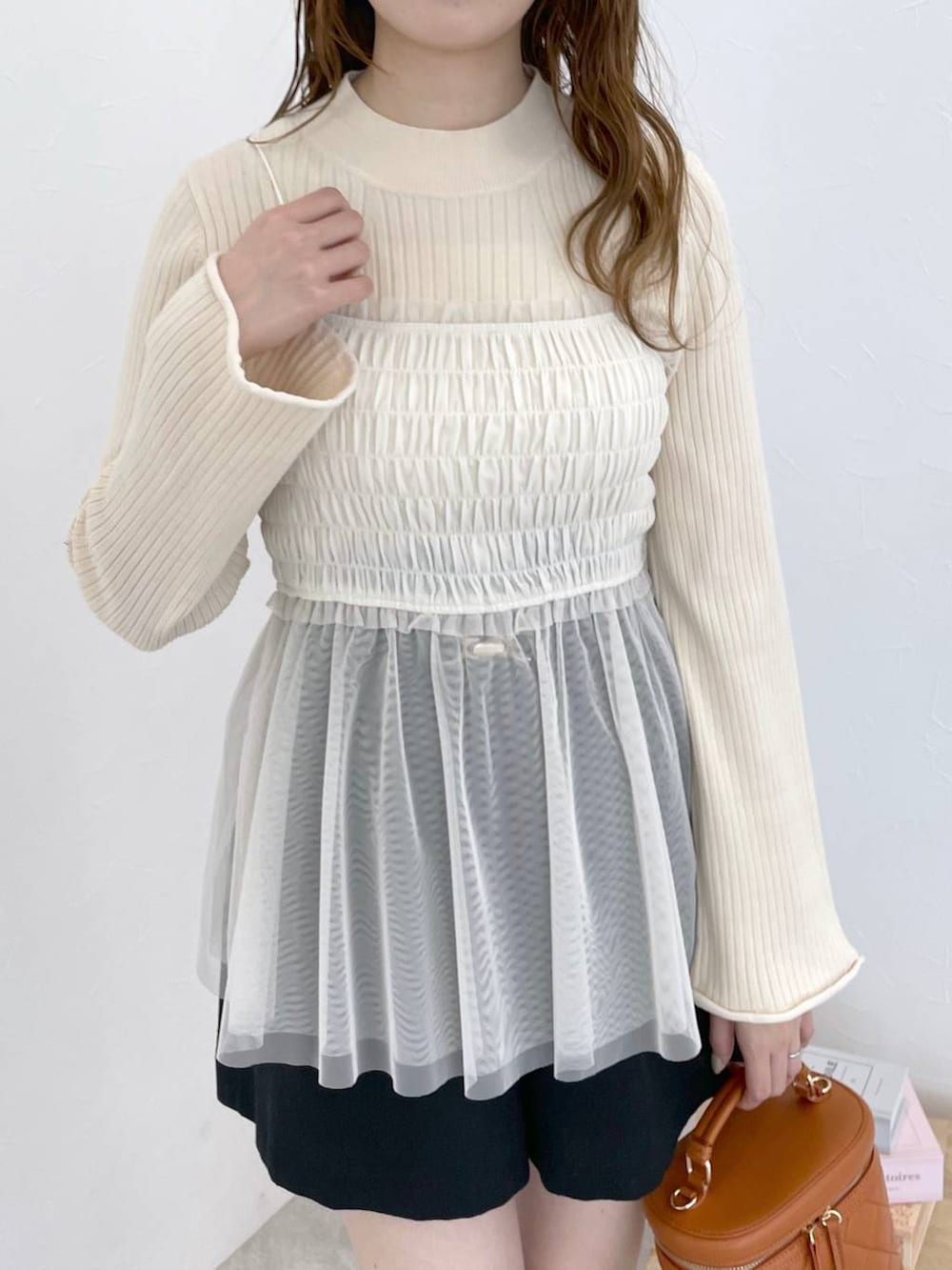 ブラック系のブーツ、オレンジ系のショルダーバッグ、ブラック系のその他パンツを着用したレディースの冬コーディネートの4枚目の写真