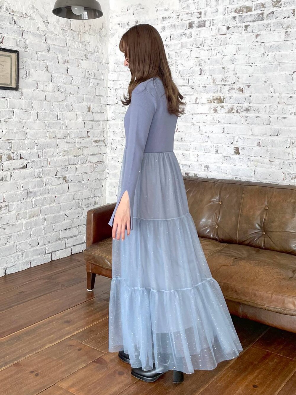 ブラック系のハンドバッグ、ブラック系のブーツ、ブルー系のワンピースを着用したレディースの秋コーディネートの2枚目の写真