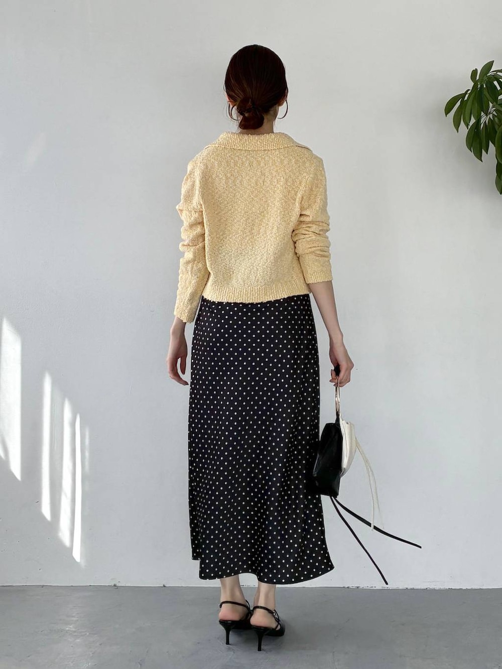 ブラック系のサンダル、イエロー系のカーディガン/ボレロ、ブラック系のスカートを着用したレディースの冬コーディネートの3枚目の写真