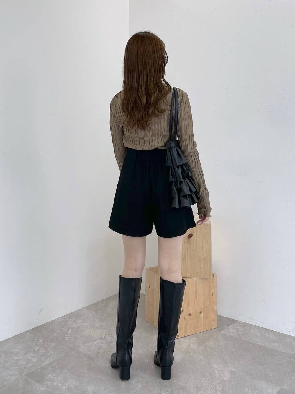 ブラック系のブーツ、ブラウン系のTシャツ/カットソー、ホワイト系のニット/セーターを着用したレディースの秋コーディネートの7枚目の写真
