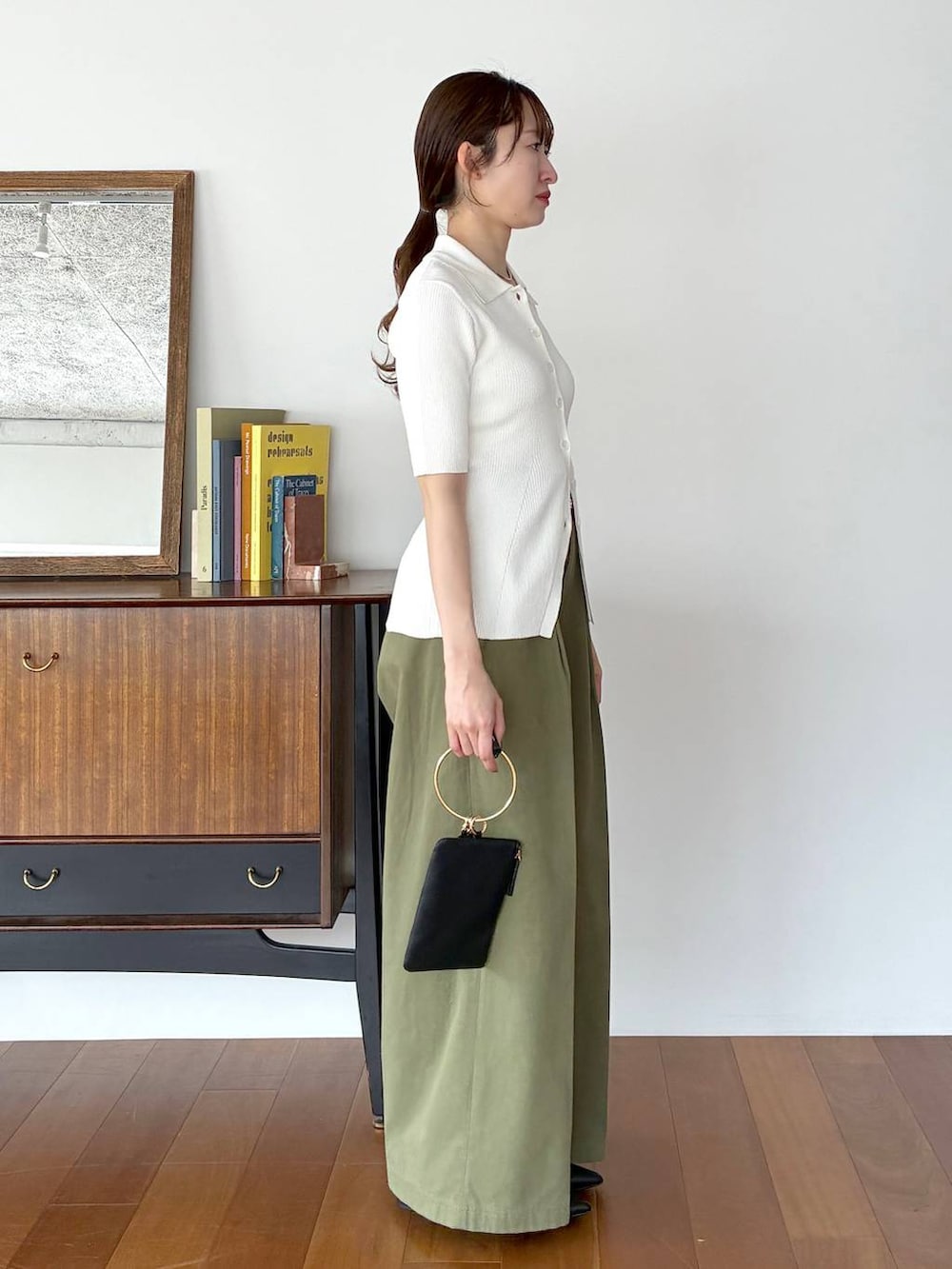 ブラック系のパンプス、ブラック系のショルダーバッグ、ホワイト系のカーディガン/ボレロを着用したレディースの春コーディネートの4枚目の写真