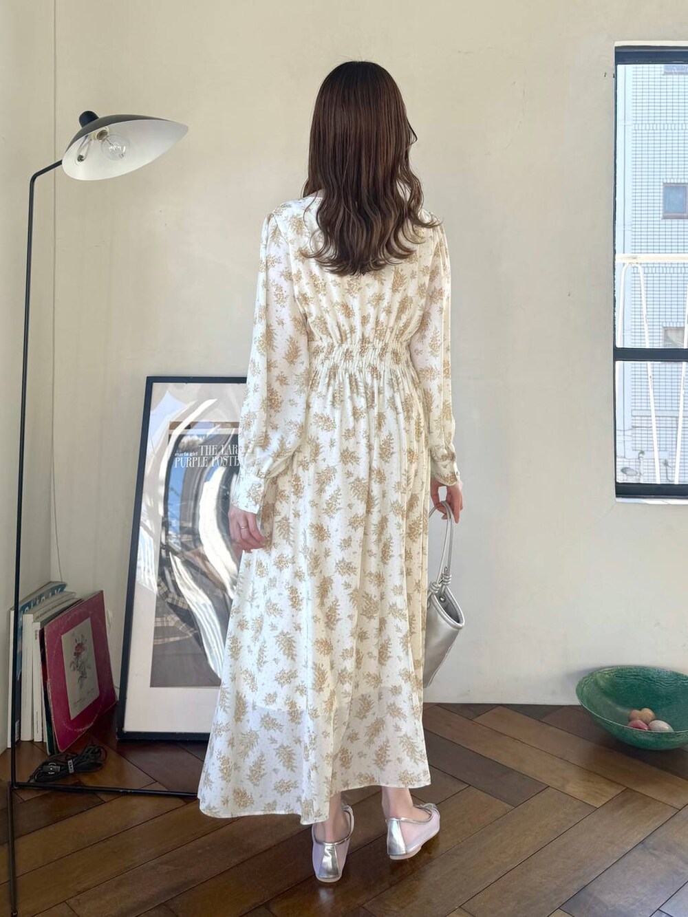 シルバー系のバレエシューズ、イエロー系のワンピース、シルバー系のハンドバッグを着用したレディースの冬コーディネートの3枚目の写真