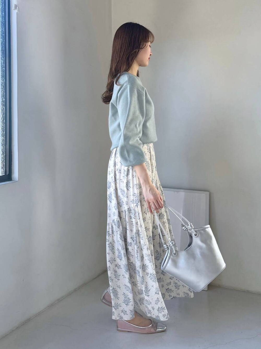 シルバー系のバレエシューズ、ブルー系のスカート、グリーン系のニット/セーターを着用したレディースの冬コーディネートの2枚目の写真