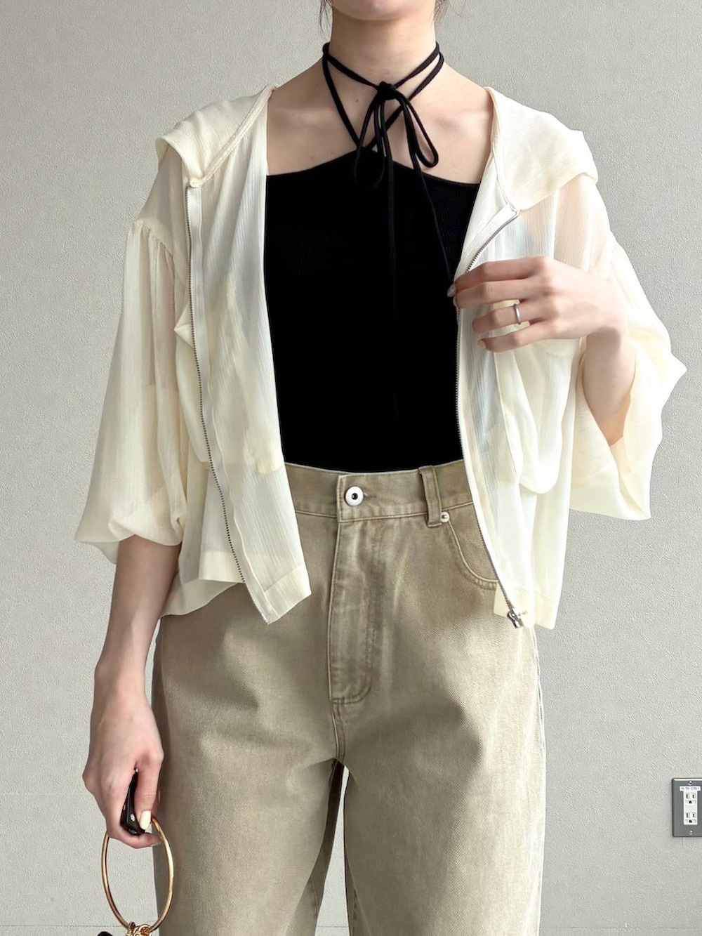 ホワイト系のパーカー、ブラック系のサンダル、ブラック系のショルダーバッグを着用したレディースの春コーディネートの5枚目の写真