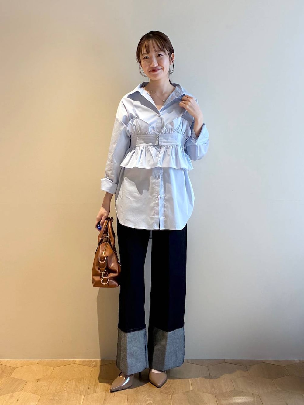 ブラウン系のボストンバッグ、ブラウン系のサンダル、ブルー系のシャツ/ブラウスを着用したレディースの冬コーディネートの5枚目の写真