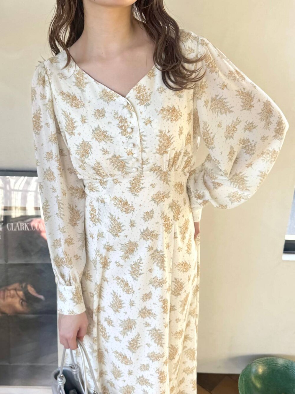 シルバー系のバレエシューズ、イエロー系のワンピース、シルバー系のハンドバッグを着用したレディースの冬コーディネートの4枚目の写真