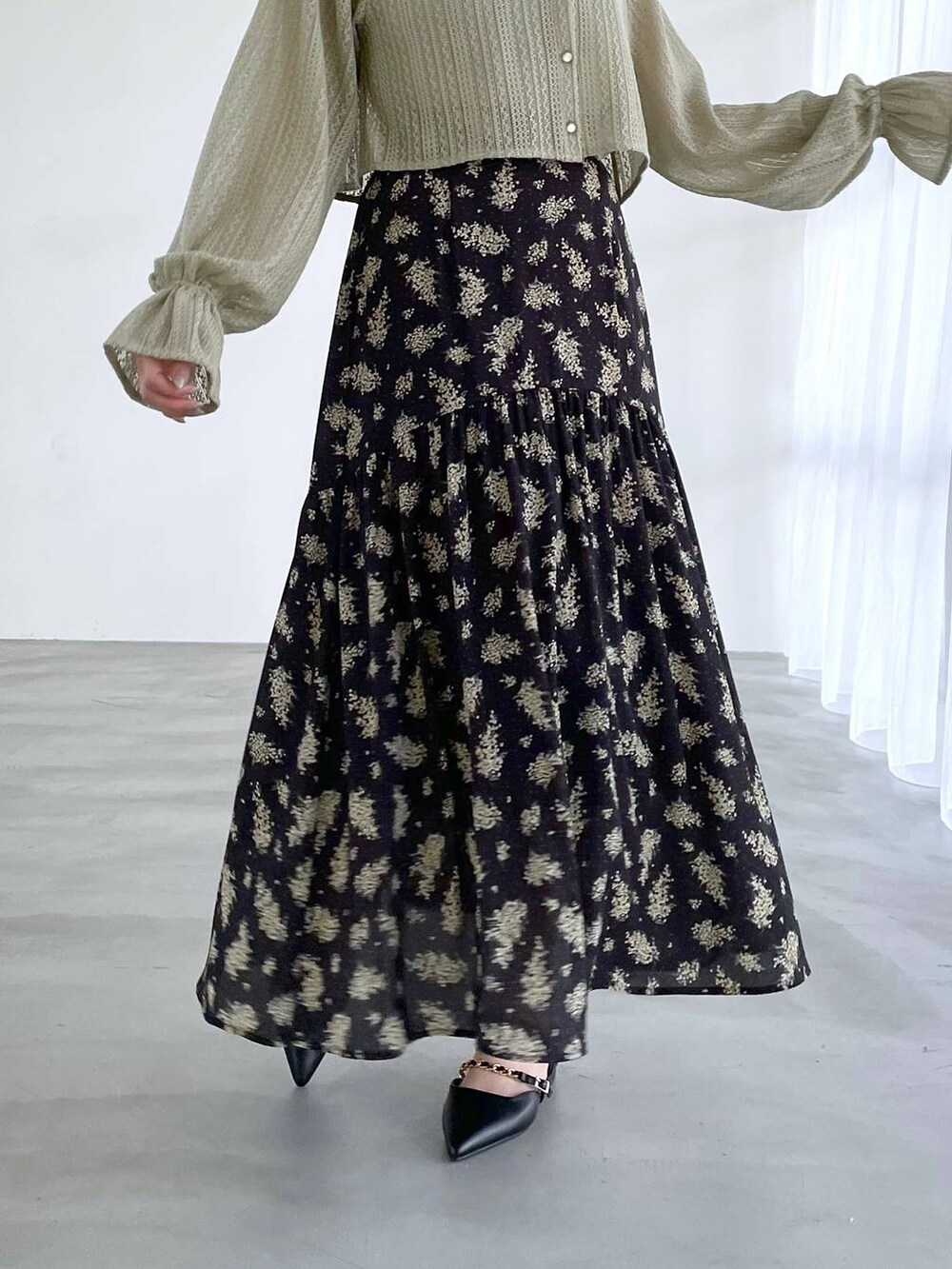 ブラック系のスカート、グリーン系のTシャツ/カットソー、ブラック系のパンプスを着用したレディースの冬コーディネートの3枚目の写真