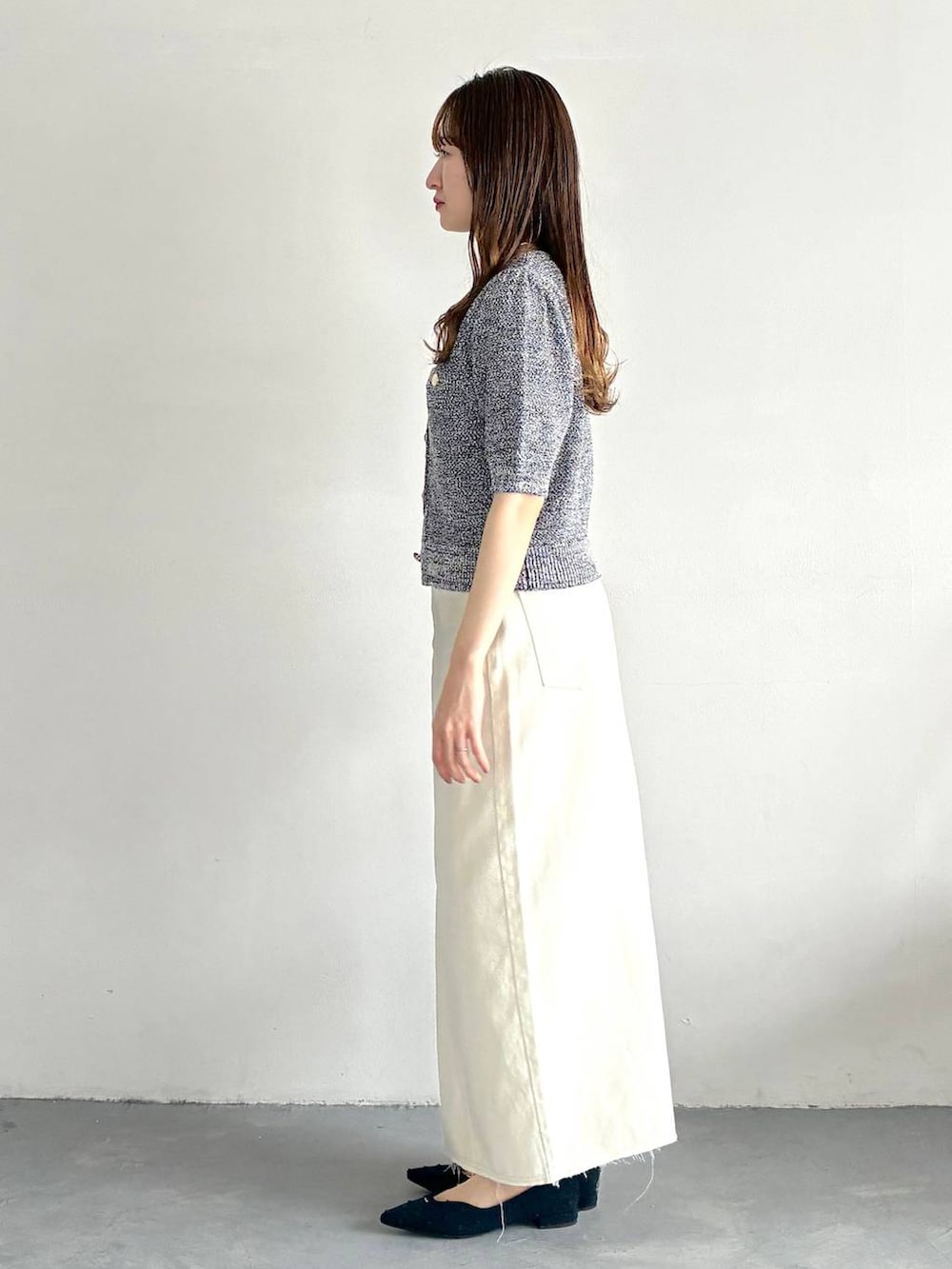 ブルー系のカーディガン/ボレロ、ブルー系のパンプス、ブラック系のショルダーバッグを着用したレディースの春コーディネートの2枚目の写真