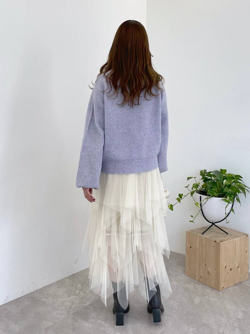 パープル系のニット/セーター、グレー系のブーツ、ホワイト系のショルダーバッグを着用したレディースの冬コーディネートの3枚目の写真