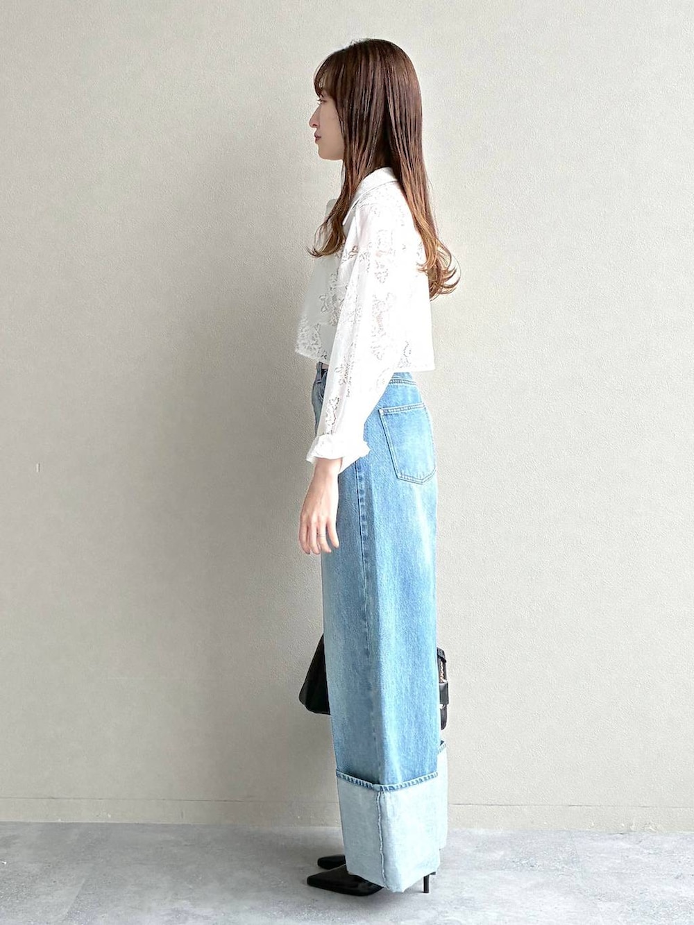 ブラック系のサンダル、ホワイト系のワンピース、ブラック系のショルダーバッグを着用したレディースの春コーディネートの2枚目の写真