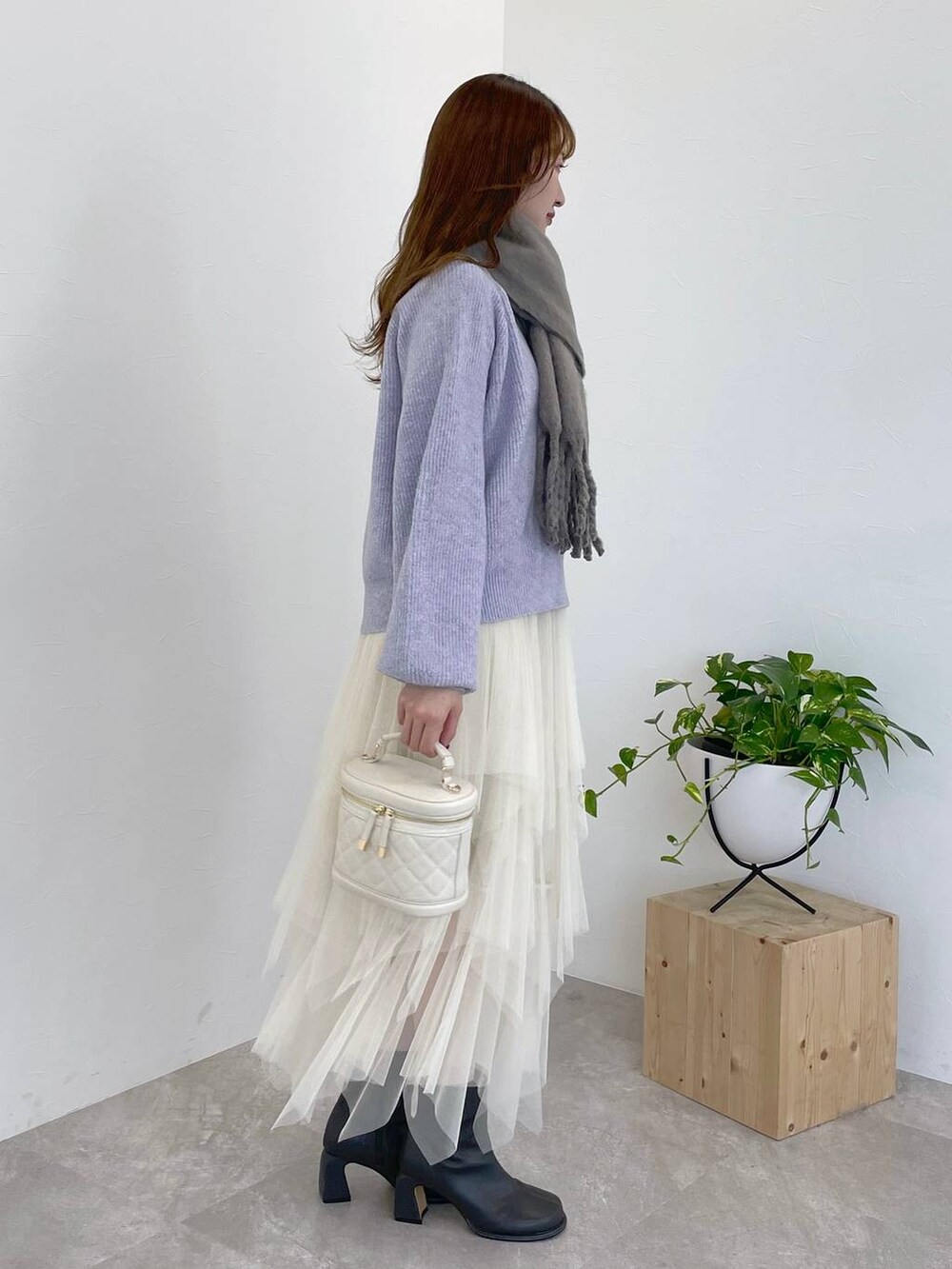 パープル系のニット/セーター、グレー系のブーツ、ホワイト系のショルダーバッグを着用したレディースの冬コーディネートの4枚目の写真