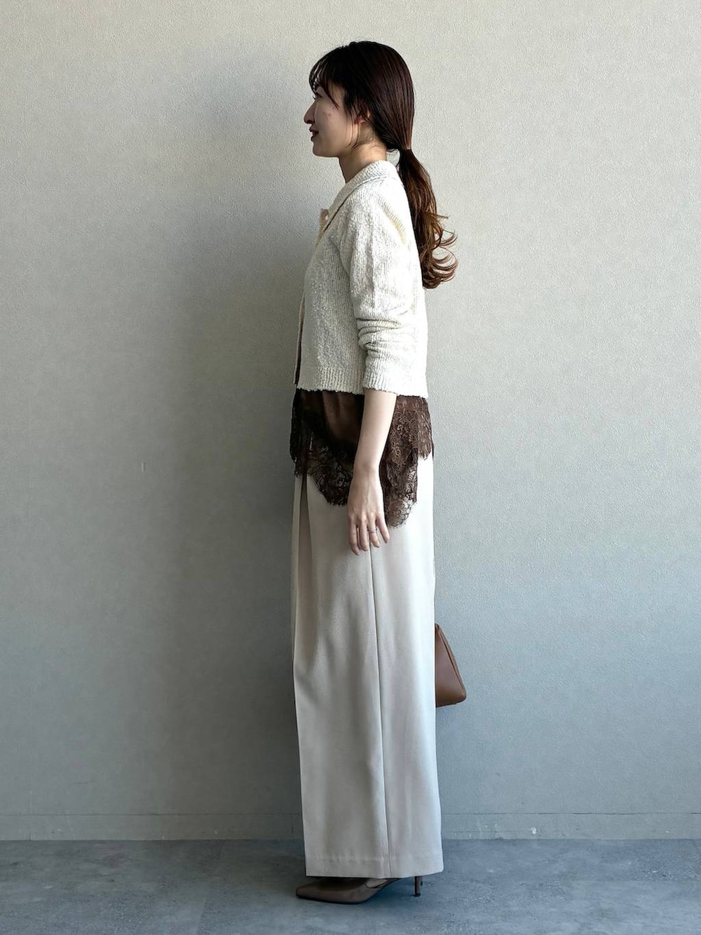 ブラウン系のサンダル、ブラウン系のキャミソール、ホワイト系のカーディガン/ボレロを着用したレディースの冬コーディネートの2枚目の写真