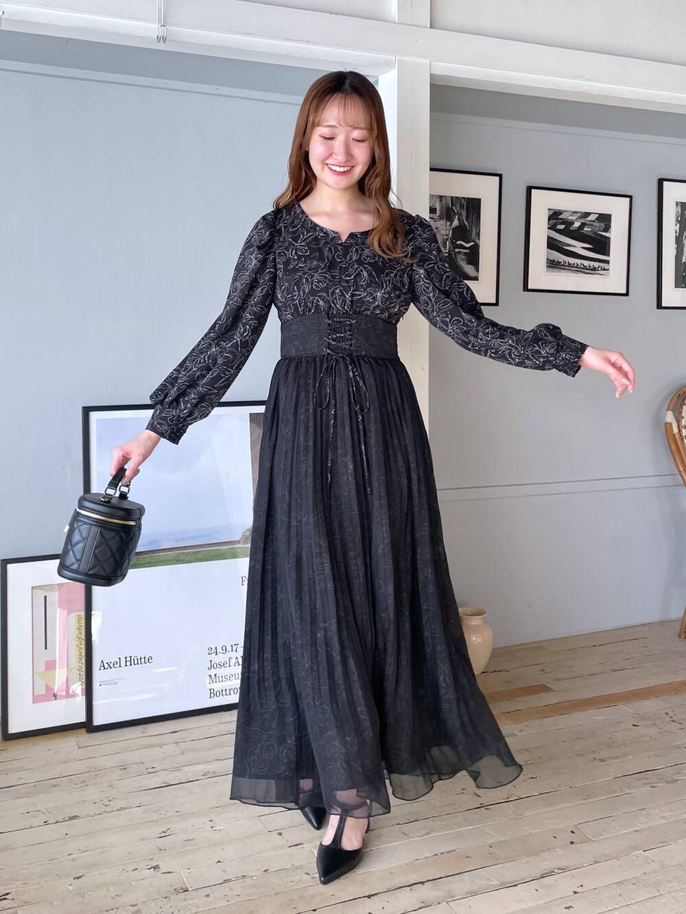 ブラック系のワンピース、ブラック系のショルダーバッグ、ブラック系のパンプスを着用したレディースの冬コーディネートの5枚目の写真