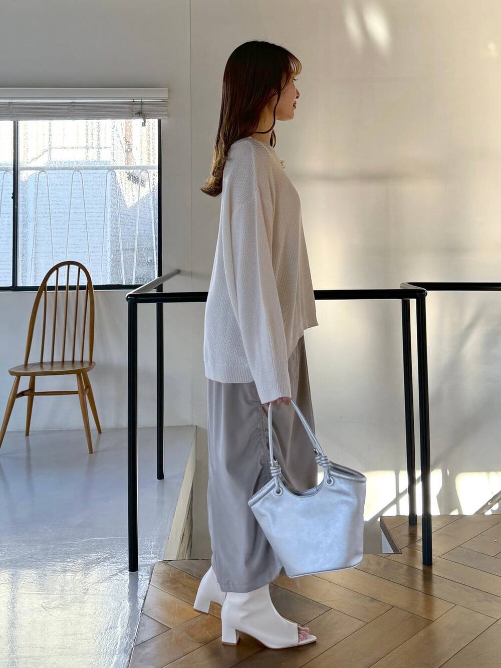 ベージュ系のスカート、ホワイト系のTシャツ/カットソー、ホワイト系のブーツを着用したレディースの冬コーディネートの2枚目の写真