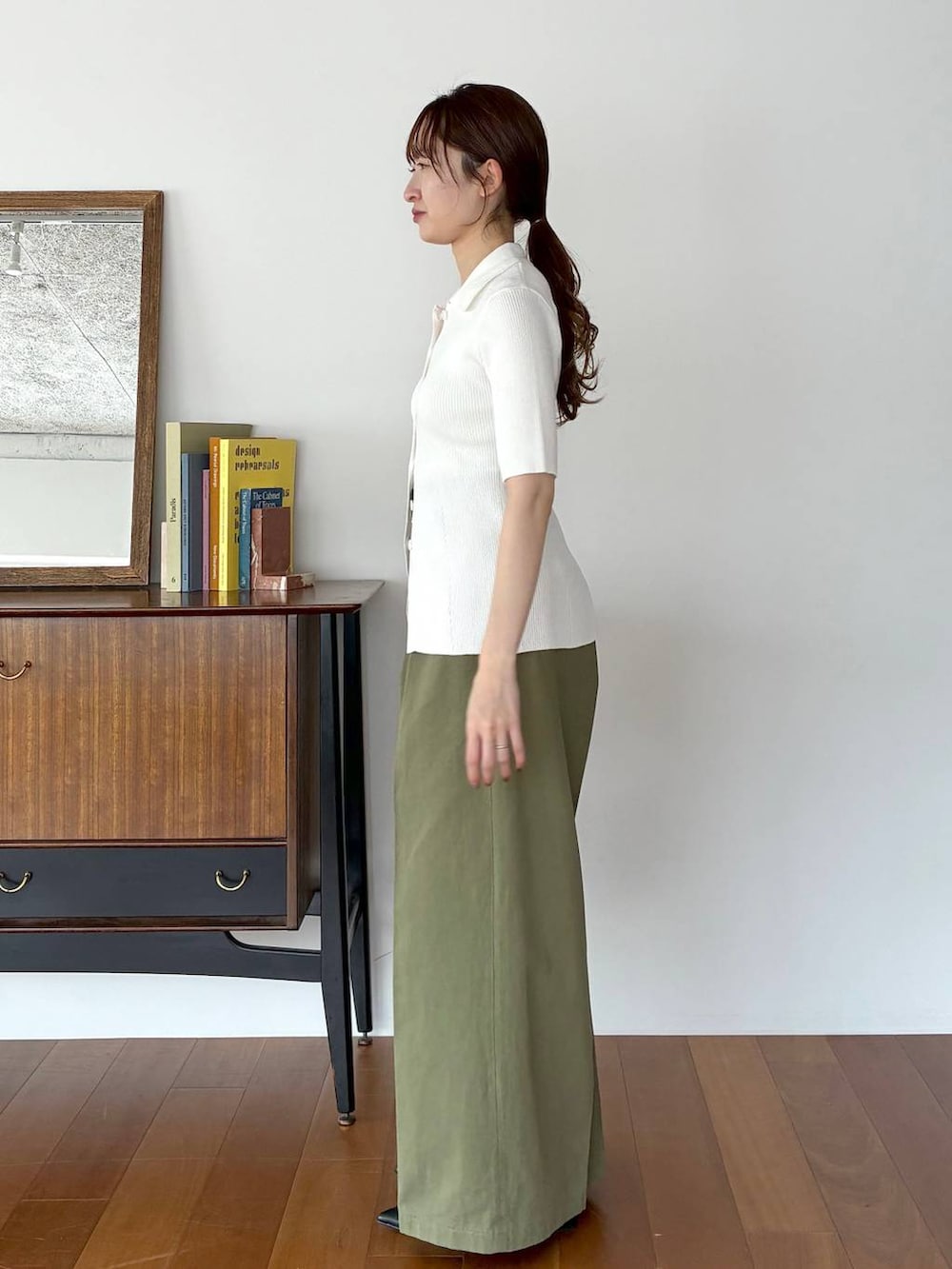 ブラック系のパンプス、ブラック系のショルダーバッグ、ホワイト系のカーディガン/ボレロを着用したレディースの春コーディネートの2枚目の写真