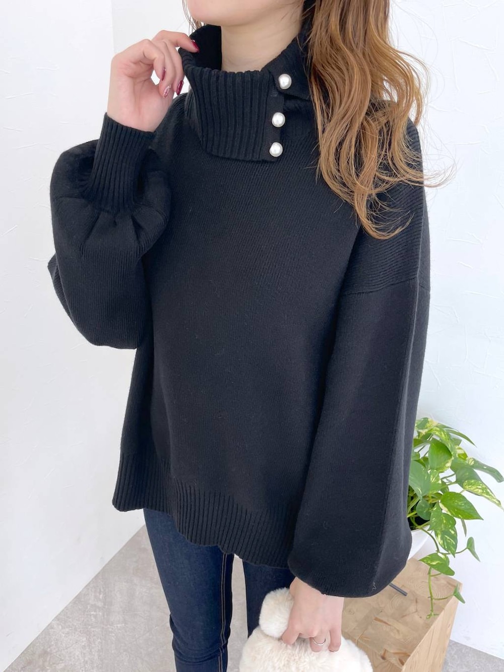 ブルー系のデニムパンツ、ブラック系のブーツ、ホワイト系のハンドバッグを着用したレディースの冬コーディネートの4枚目の写真