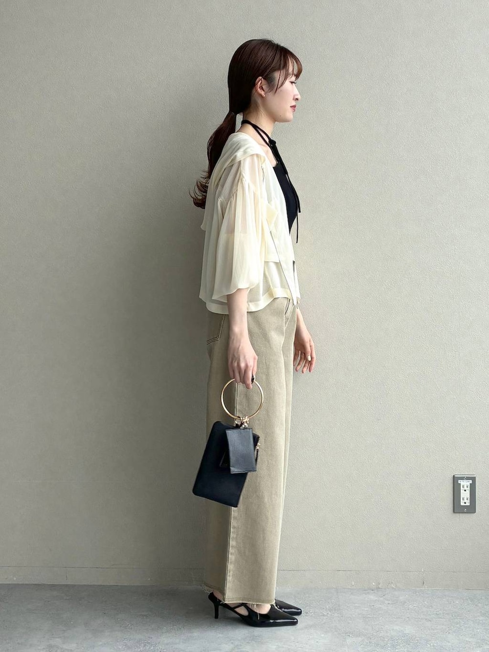 ホワイト系のパーカー、ブラック系のサンダル、ブラック系のショルダーバッグを着用したレディースの春コーディネートの4枚目の写真