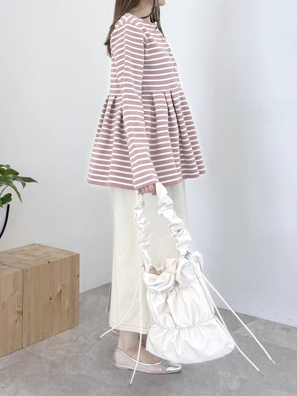 ピンク系のカーディガン/ボレロ、シルバー系のバレエシューズ、ホワイト系のスカートを着用したレディースの春コーディネートの2枚目の写真