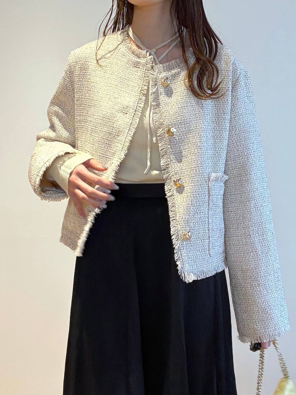 ブラック系のパンプス、ホワイト系のニット/セーター、ホワイト系のノーカラージャケットを着用したレディースの春コーディネートの5枚目の写真