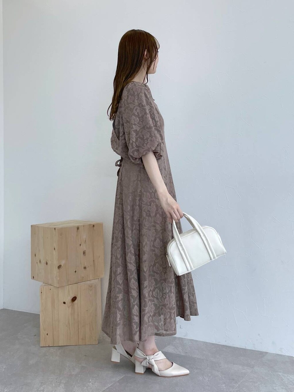 ホワイト系のボストンバッグ、ブラウン系のワンピース、ホワイト系のパンプスを着用したレディースの秋コーディネートの2枚目の写真