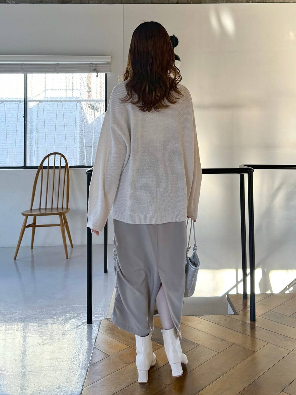 ベージュ系のスカート、ホワイト系のTシャツ/カットソー、ホワイト系のブーツを着用したレディースの冬コーディネートの3枚目の写真