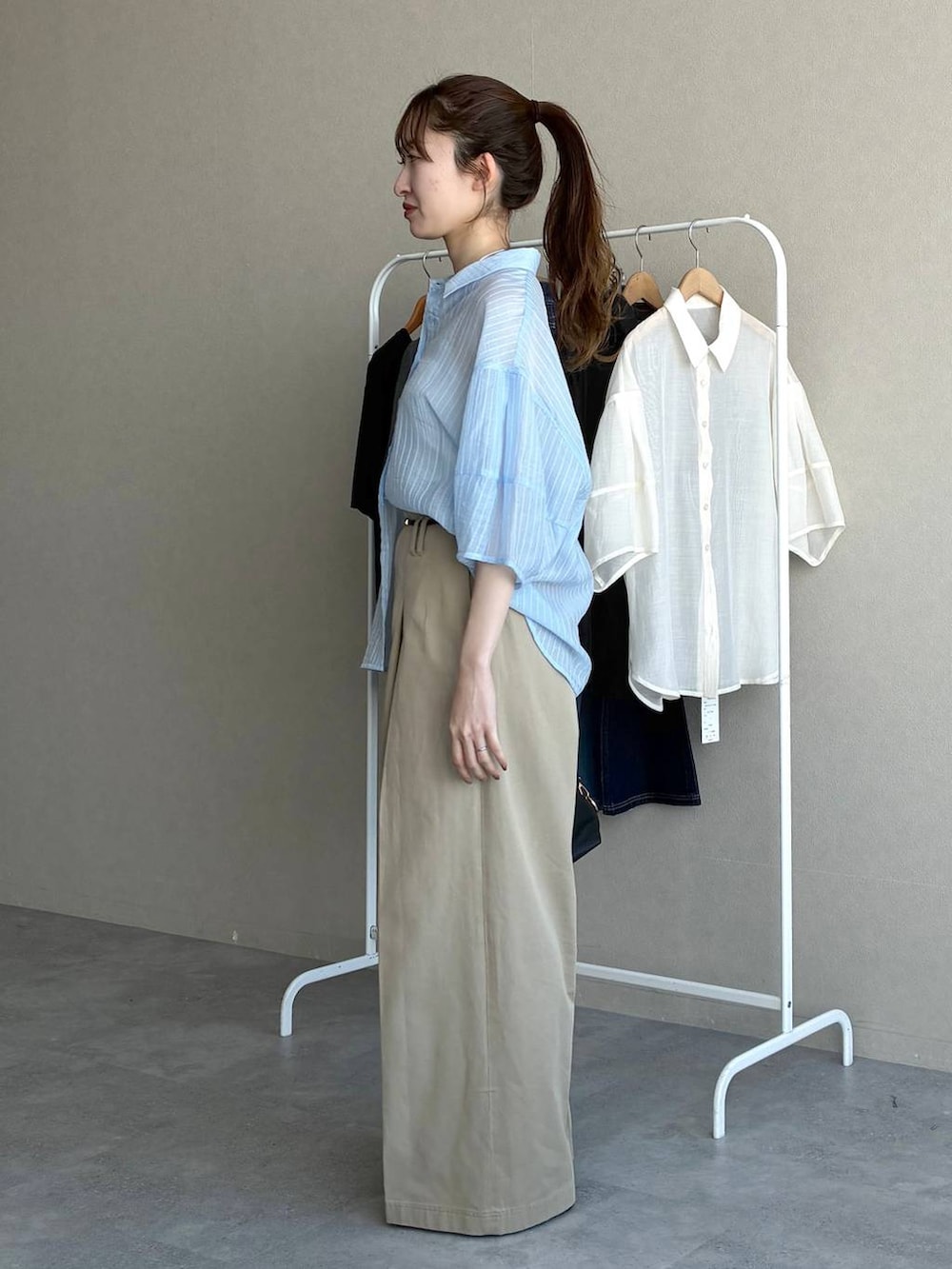 ブラック系のボストンバッグ、ブラック系のローファー、ブルー系のシャツ/ブラウスを着用したレディースの春コーディネートの2枚目の写真