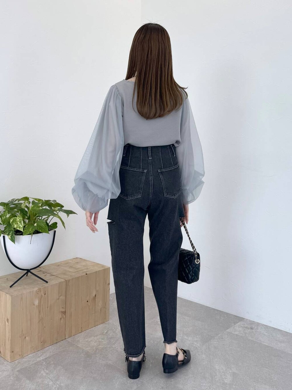 グレー系のTシャツ/カットソー、ブラック系のショルダーバッグ、ブラック系のデニムパンツを着用したレディースの冬コーディネートの3枚目の写真